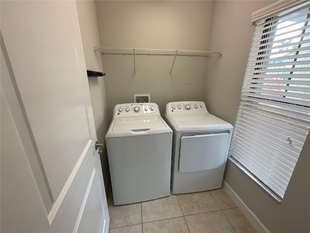 laundry room with separate washer and dryer and light tile patterned floors