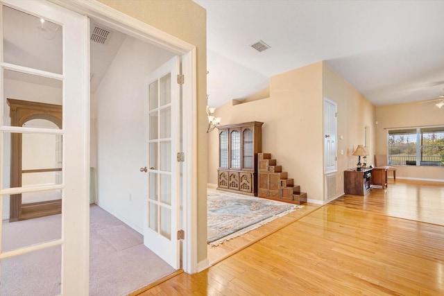 corridor with lofted ceiling, french doors, and hardwood / wood-style flooring