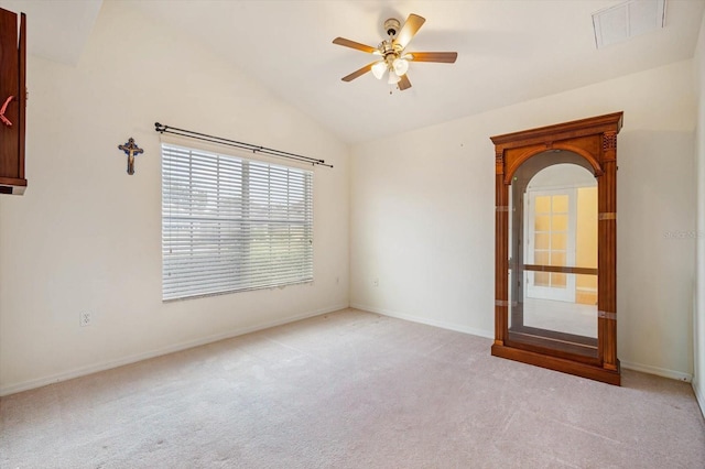 empty room with ceiling fan, light colored carpet, and vaulted ceiling