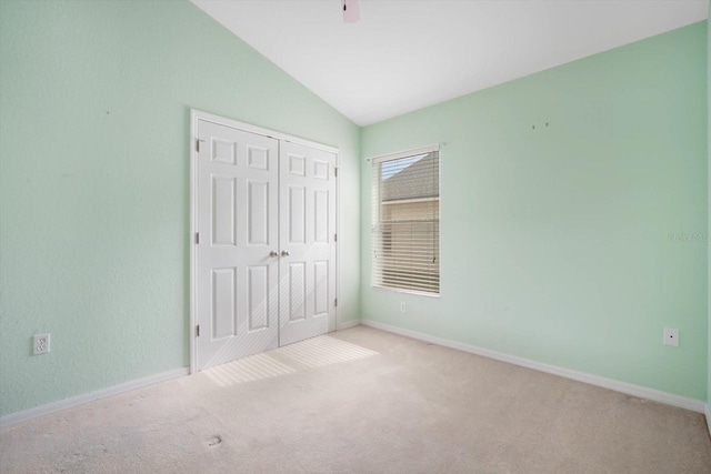 unfurnished bedroom with lofted ceiling, light colored carpet, a closet, and ceiling fan