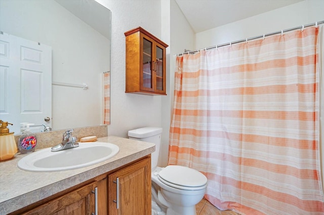 bathroom with toilet, vanity, and tile patterned floors