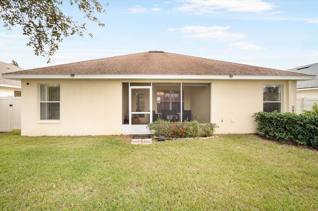 rear view of property with a sunroom and a yard