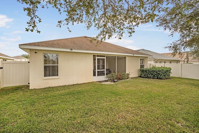 rear view of house featuring a yard