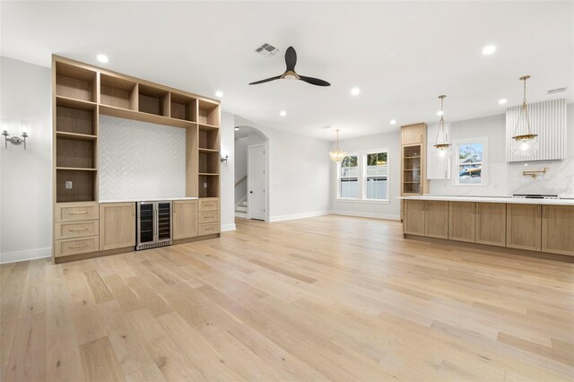 unfurnished living room featuring light wood-type flooring, beverage cooler, a ceiling fan, and recessed lighting