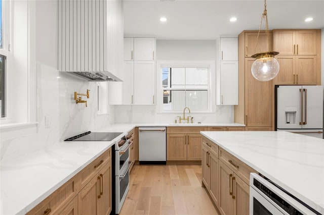 kitchen featuring white appliances, a sink, range hood, decorative backsplash, and light wood finished floors