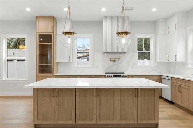 kitchen featuring light wood-style floors, a healthy amount of sunlight, dishwasher, and backsplash