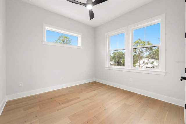 spare room featuring light wood-type flooring, baseboards, and a ceiling fan