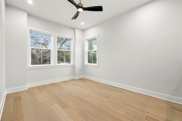 empty room with light wood finished floors, recessed lighting, a ceiling fan, and baseboards