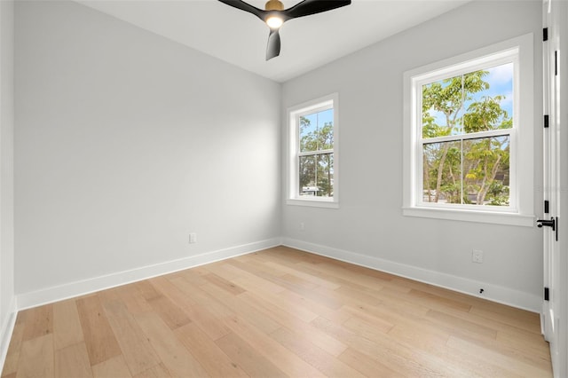 empty room with baseboards, a wealth of natural light, and light wood-style floors