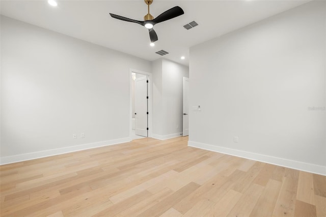 unfurnished room with light wood-type flooring, visible vents, and baseboards