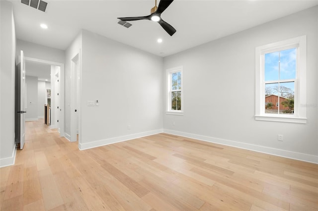 unfurnished room with light wood-style floors, plenty of natural light, visible vents, and baseboards