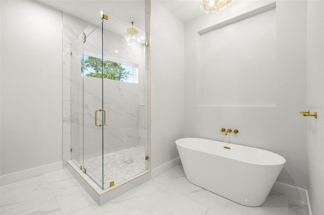 bathroom featuring marble finish floor, a freestanding tub, and a marble finish shower