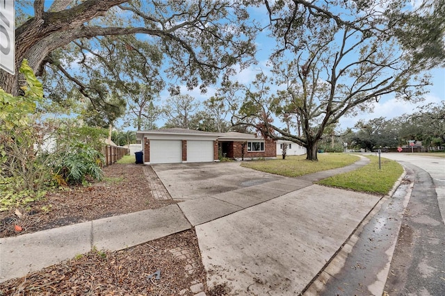 ranch-style home with a garage and a front lawn