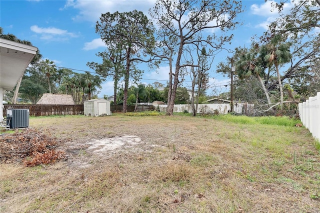 view of yard with central AC and a storage unit