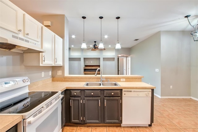 kitchen with sink, white appliances, decorative light fixtures, and white cabinetry