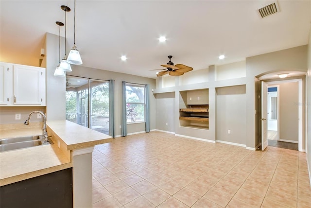 kitchen with pendant lighting, white cabinetry, sink, light tile patterned flooring, and ceiling fan