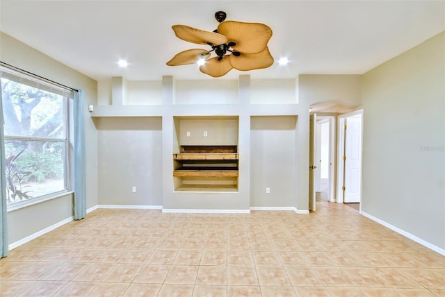 unfurnished living room featuring plenty of natural light and ceiling fan