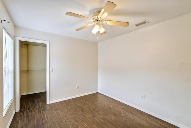 unfurnished bedroom featuring ceiling fan, dark hardwood / wood-style floors, and a closet