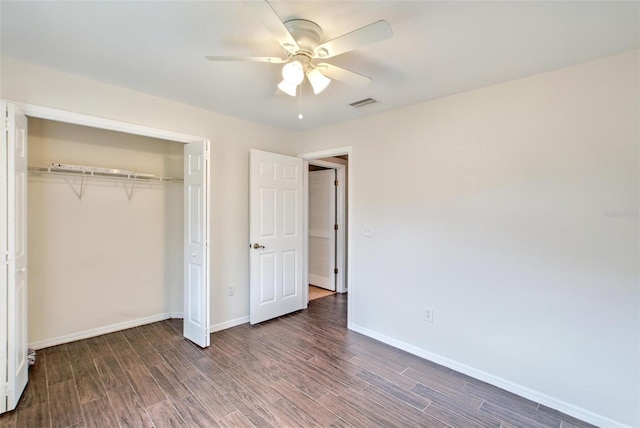 unfurnished bedroom with ceiling fan, dark hardwood / wood-style floors, and a closet