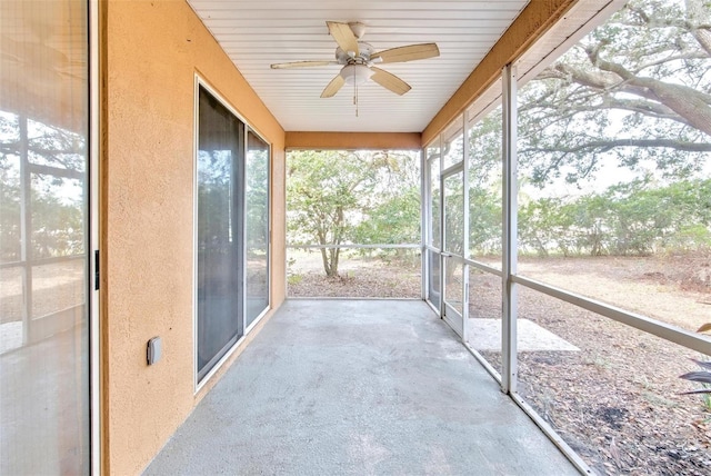 unfurnished sunroom with ceiling fan