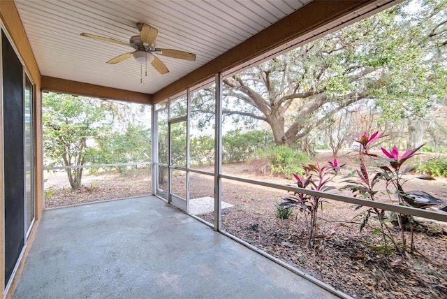 unfurnished sunroom featuring ceiling fan and a healthy amount of sunlight