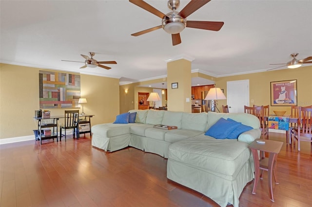 living room featuring wood-type flooring, ornamental molding, and ceiling fan