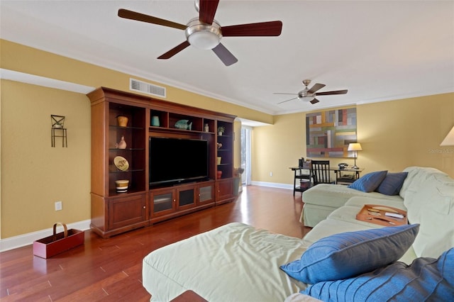 living room featuring dark wood-type flooring, ornamental molding, and ceiling fan