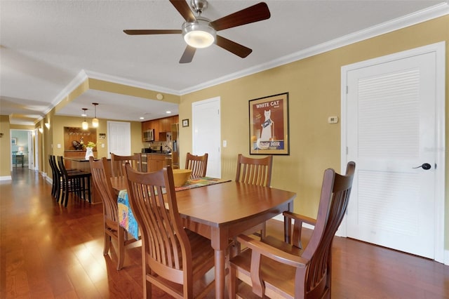 dining room with ornamental molding, hardwood / wood-style floors, and ceiling fan