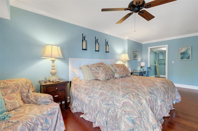 bedroom with a walk in closet, crown molding, and dark wood-type flooring