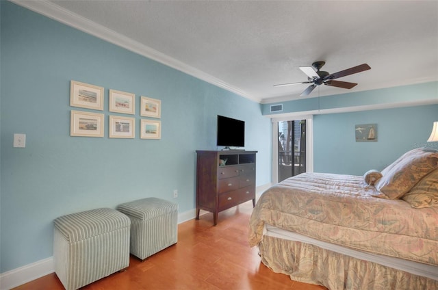 bedroom with crown molding, ceiling fan, wood-type flooring, and a textured ceiling