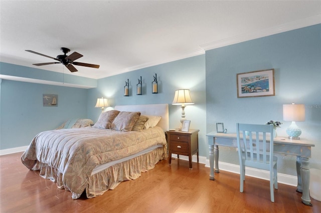 bedroom featuring hardwood / wood-style floors, crown molding, and ceiling fan