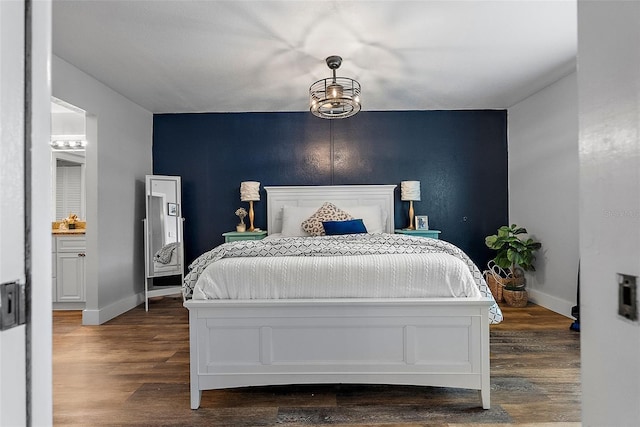 bedroom with ensuite bath and dark hardwood / wood-style flooring