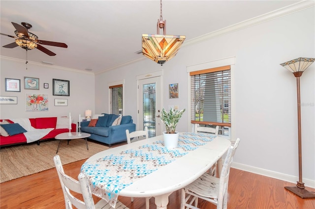 dining area featuring ornamental molding, ceiling fan, and light wood-type flooring