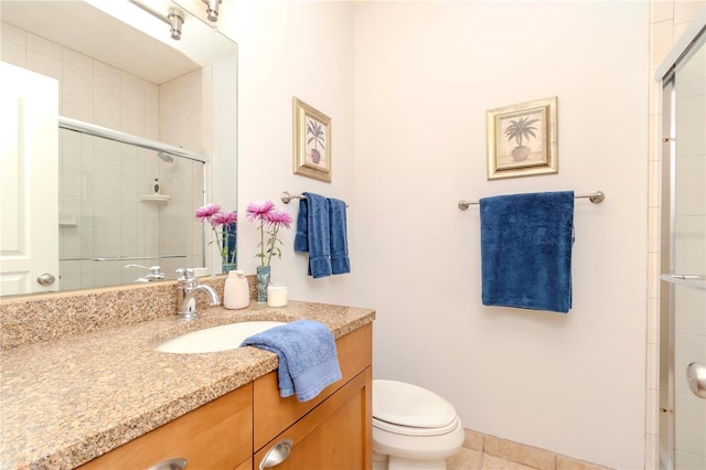 bathroom with vanity, toilet, and a shower with door