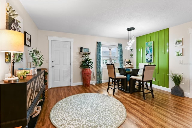 dining room with hardwood / wood-style flooring and a textured ceiling