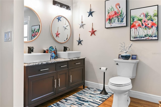 bathroom with hardwood / wood-style floors, toilet, and vanity