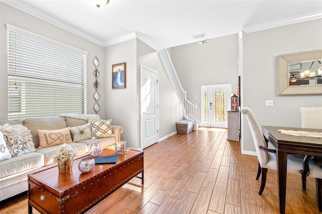 living room with a healthy amount of sunlight, ornamental molding, and hardwood / wood-style floors