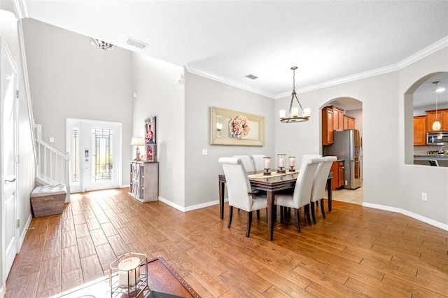 dining space with crown molding, a chandelier, and light hardwood / wood-style floors