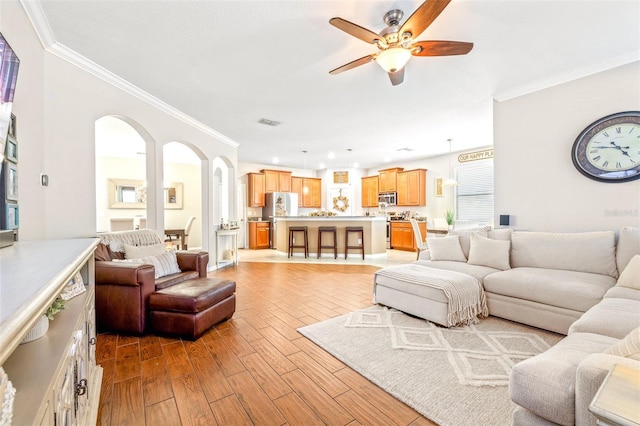 living room featuring crown molding and ceiling fan