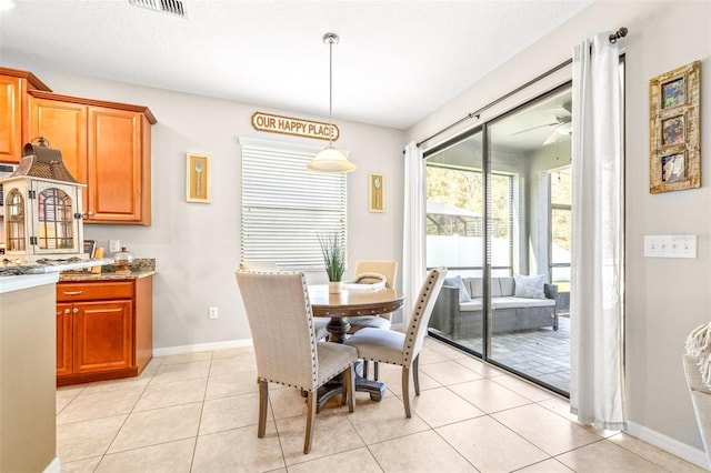 dining area featuring light tile patterned floors, a textured ceiling, and ceiling fan