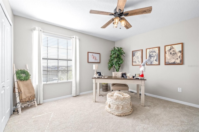 home office with a healthy amount of sunlight, light colored carpet, and ceiling fan