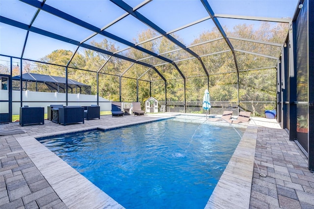 view of swimming pool with a patio, pool water feature, and glass enclosure