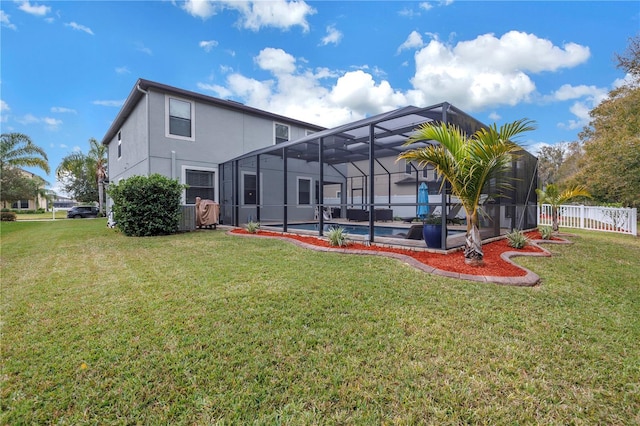 rear view of property featuring a yard and glass enclosure