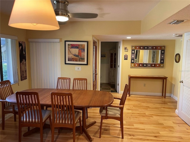 dining area with light hardwood / wood-style floors and ceiling fan