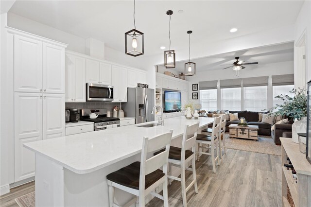 kitchen featuring a kitchen breakfast bar, sink, a kitchen island with sink, and stainless steel appliances