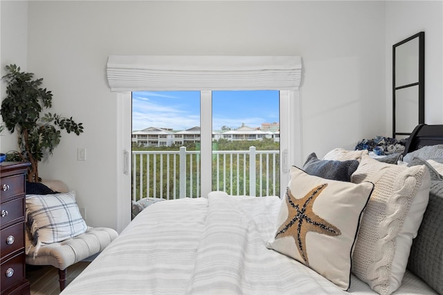 bedroom with hardwood / wood-style floors, access to outside, and multiple windows