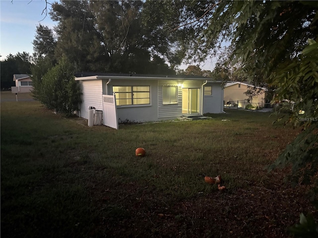 back house at dusk with a yard