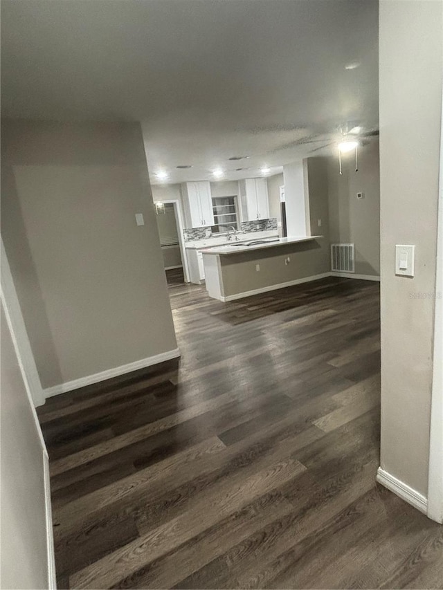 unfurnished living room with dark wood-type flooring