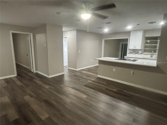 kitchen with white cabinets, dark hardwood / wood-style flooring, black electric cooktop, and tasteful backsplash