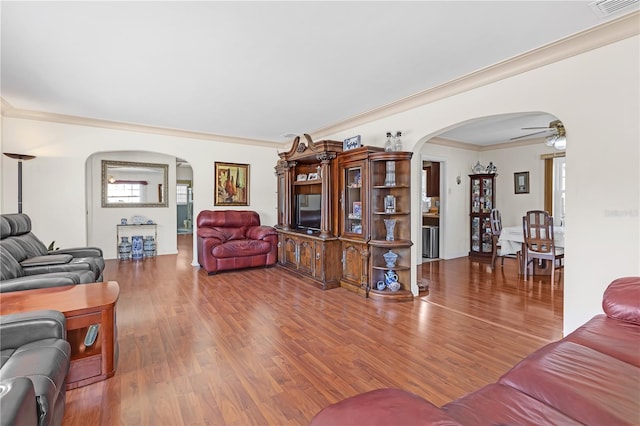 living room with ceiling fan, ornamental molding, and wood-type flooring